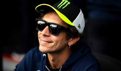 Valentino Rossi standing on the podium holding a trophy