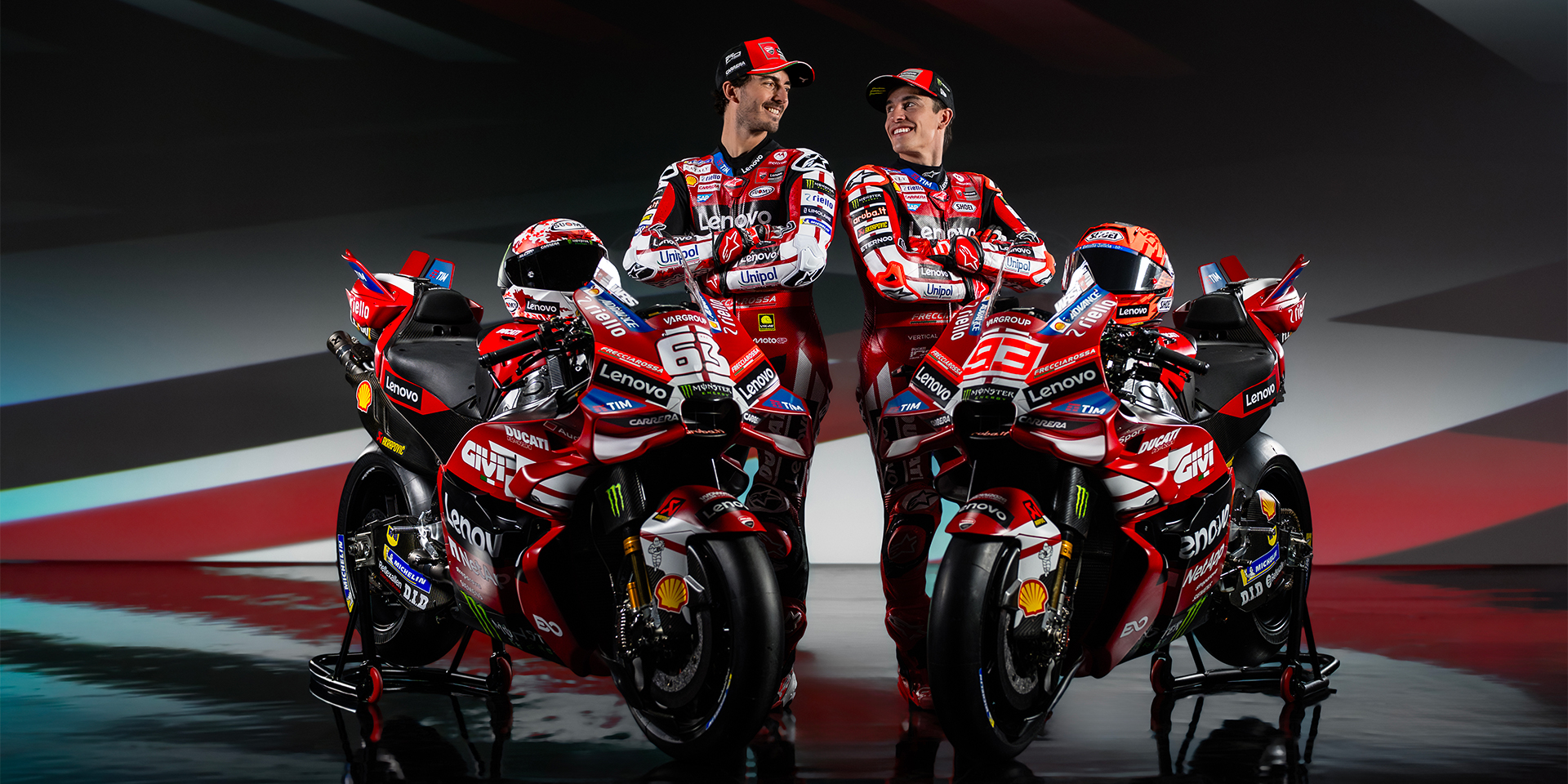Ducati Corse factory garage with mechanics working on a MotoGP bike under bright lights