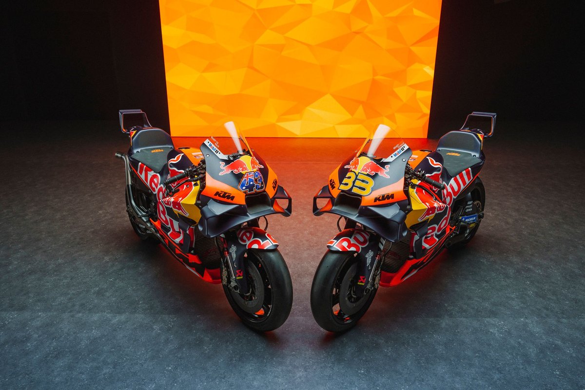 KTM rider executing a high-speed overtake on a Ducati through a sweeping corner