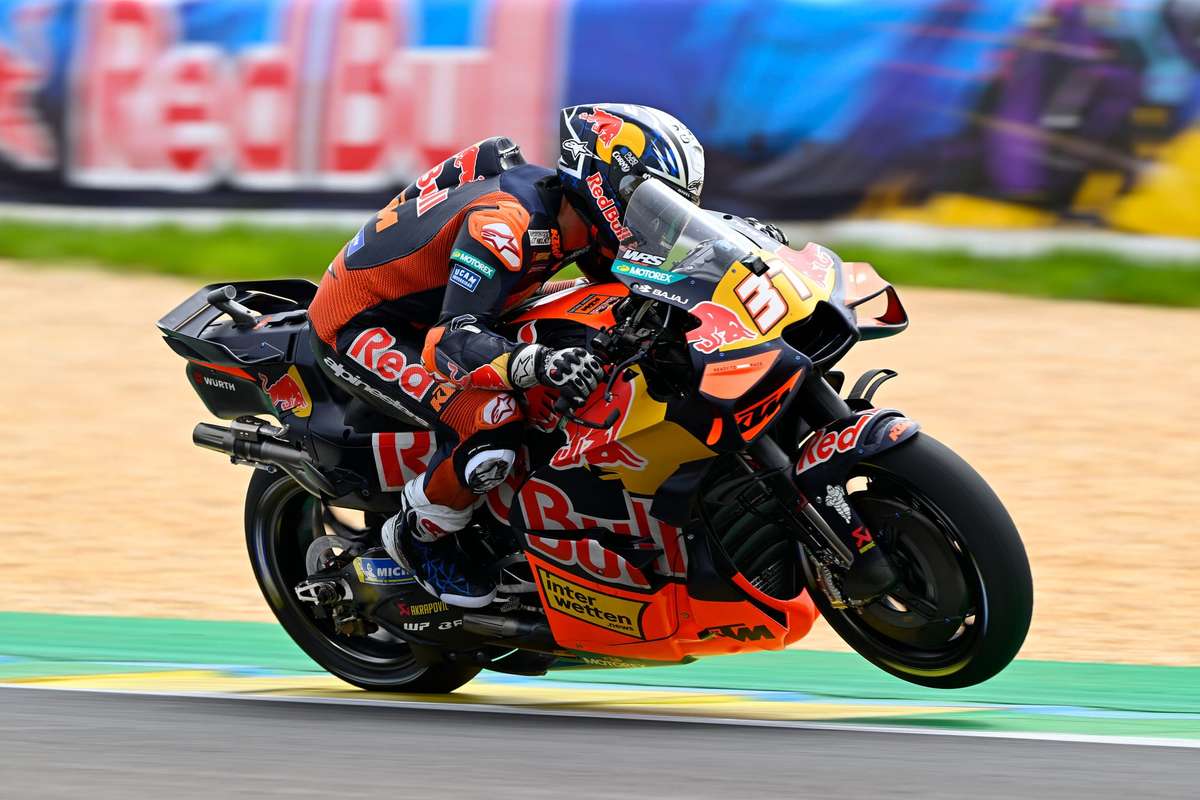 KTM MotoGP prototype undergoing testing with engineers observing data at the circuit pit lane