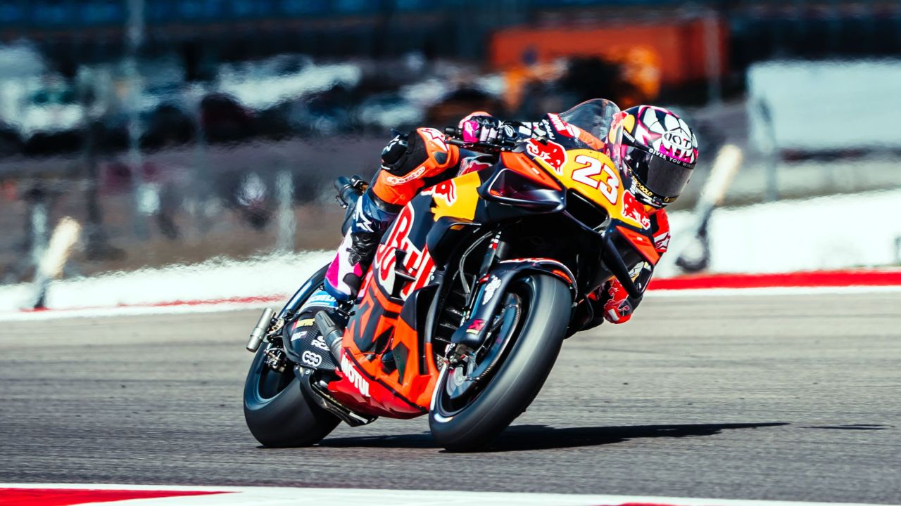 KTM MotoGP bike on the starting grid with mechanics making final adjustments before the race