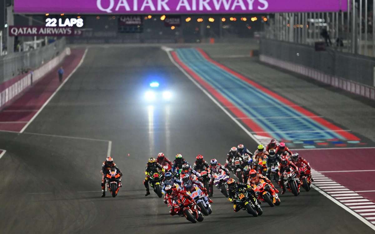 Close-up of sand deposits on the Losail racing line with a MotoGP bike approaching a turn
