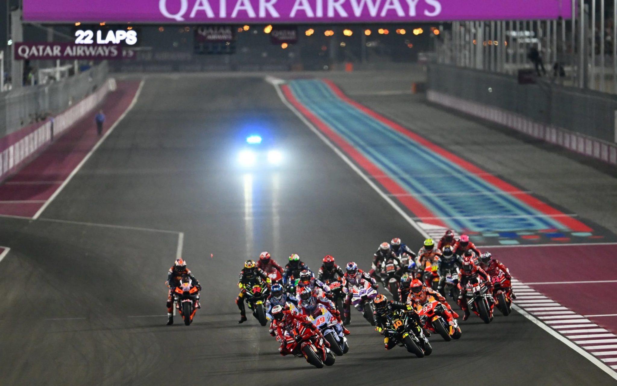 Close-up of sand deposits on the Losail racing line with a MotoGP bike approaching a turn