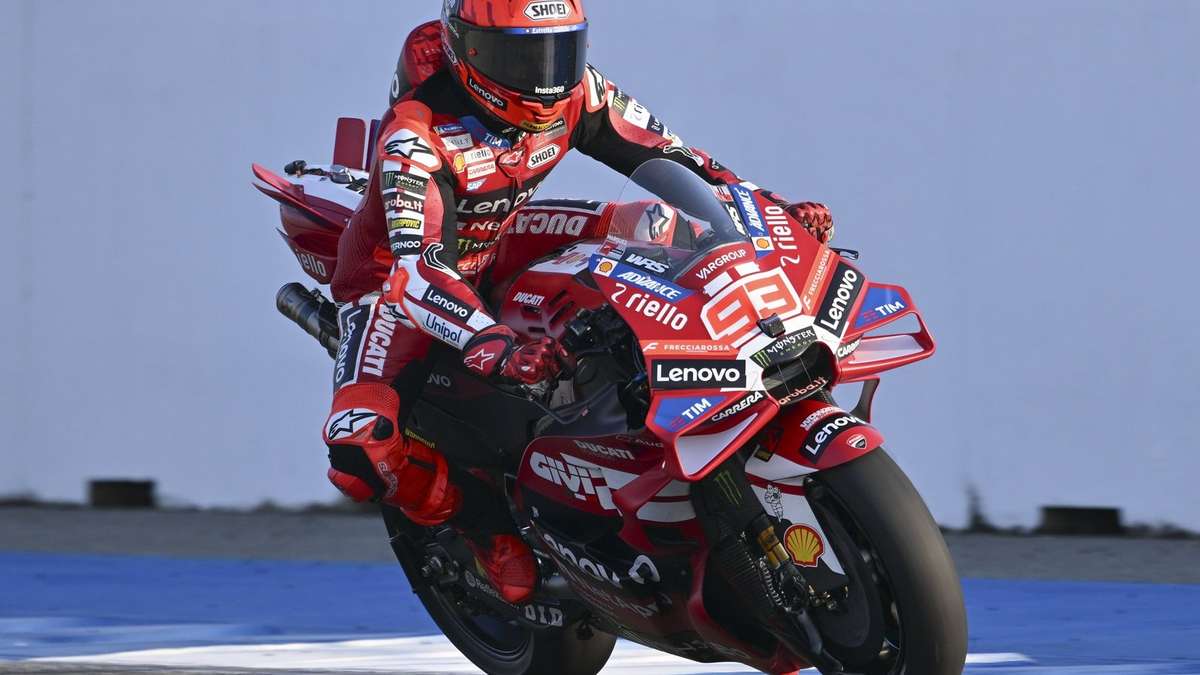 Side view of Marc Márquez trail-braking with a sharp lean angle, showing throttle control and front-end grip