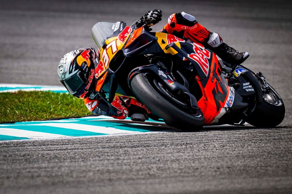 Young Pedro Acosta leaning into a turn during an early junior series race, focused expression and race leathers visible